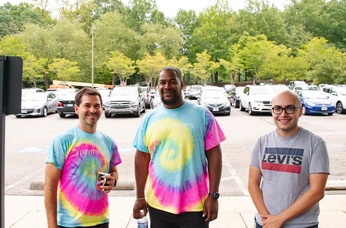 Andrew Quash standing outside with 2 engineers smiling together