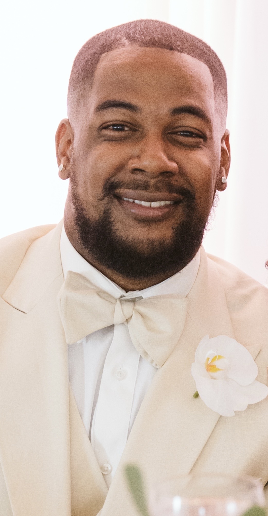 Andrew Quash smiling wearing an off-white tuxedo